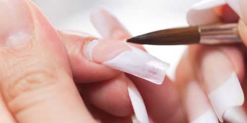 Stage of manicure: modeling of nail with acryl. Manicurist serve client in beauty salon.
